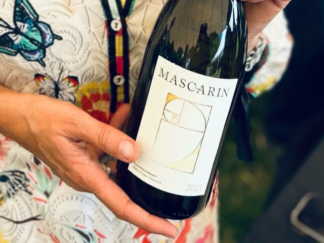 Hands holding a bottle of Mascarin 2021 Chardonnay